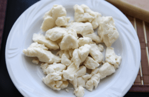 A shallow white bowl of white cheese curds.