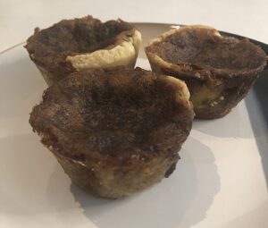 Three butter tarts on a white plate