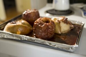 Four baked apples on a tinfoil lined tray